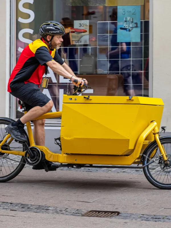 Ladcykelbud i gult foran butik